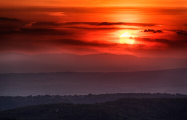 Sunset with layers of hills and mountains, soft focus. Mountain layers in sunset. Blue mountains and last sun lights landscape.