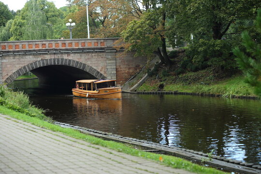 A boat under the bridge on the canal in the park of Riga. High quality photo