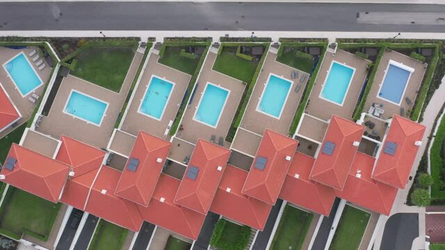 Charming resort countryside with low-rise residential complexes. Aerial view over luxury cottages with swimming pools and green lawns. High quality 4k footage