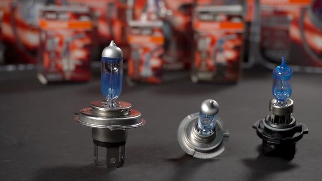 Halogen bulbs for car, panning on black background with packs, closeup
