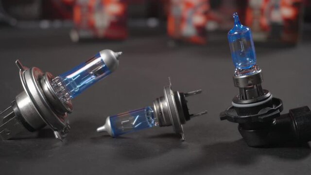 Halogen bulbs for car, panning on black background with packs, car component, closeup, h4, h7