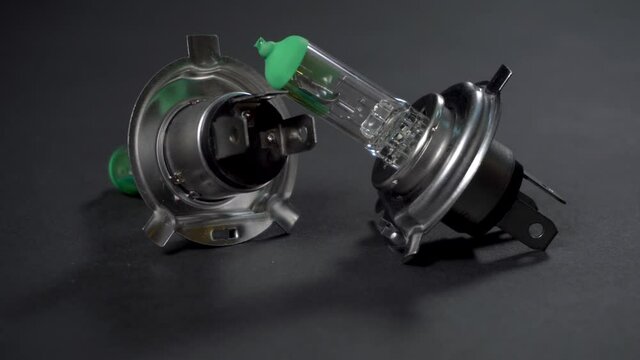 Halogen bulbs for car, panning vertically on black background, H4