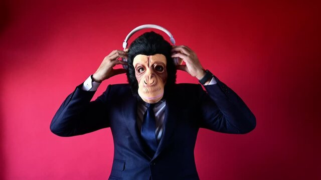 Businessman in monkey mask dancing with headphones and smartphone