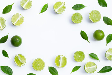 Frame made of fresh limes with green leaves on white background. Top view