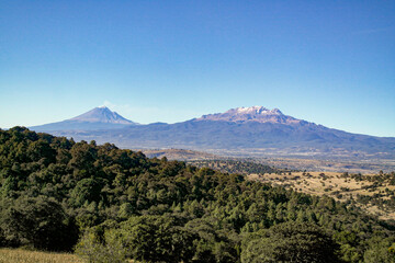Fototapeta premium Paisaje desde un parque en Puebla en donde se alcanza a ver el volcán Popocatépetl y el Iztaccíhuatl conocido como La Mujer Dormida