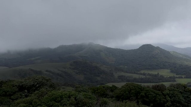 A Dramatic Time lapse video of Mandal Patti hill range covered in mist and the passing clouds in Coorg during Monsoon season in Karnataka, India.