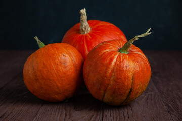 Pumpkins on wooden table in dark mood.