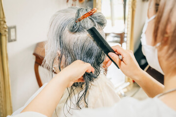Fototapeta premium 高齢者のヘアカットをする美容師（鏡） 