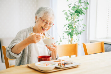 Obraz na płótnie Canvas 食事をする高齢者女性 