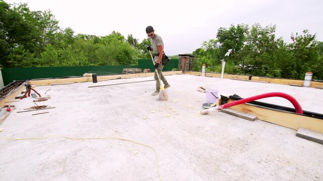 Timelapse of a builder sweeping the construction area with a broom. A formwork, temporary or permanent molds into which concrete or similar materials are poured. Building site