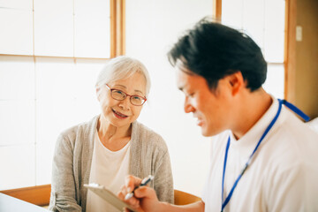 在宅介護・安否確認を受ける高齢者女性
