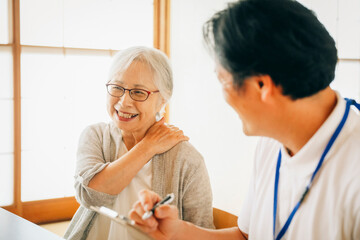 在宅介護を受ける高齢者女性（笑顔）
