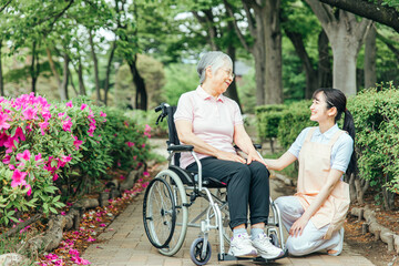 車椅子に乗った高齢者女性と女性スタッフ
