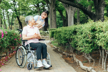 車椅子に乗った高齢者女性と女性スタッフ
