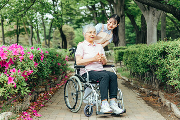 車椅子に乗った高齢者女性と女性スタッフ
