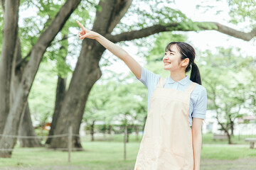 医療・介護・福祉系の女性スタッフ（指差す）
