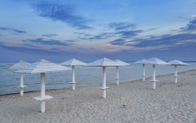 Clean clean beach with wooden umbrellas, aerial view.