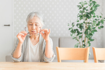 メガネを持つ高齢者女性
