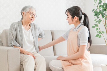 Obraz premium 訪問介護・腰をおさえる高齢者女性（腰痛） 