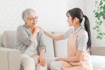Obraz premium 訪問介護する女性と高齢者（肩こり） 