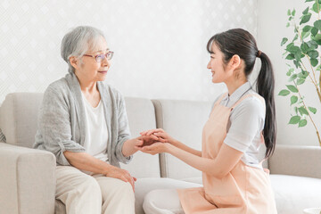 訪問介護する女性と高齢者（笑顔）
