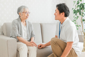 訪問介護する男性と高齢者（笑顔）
