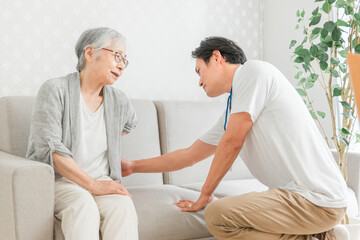 Fototapeta premium 訪問介護・腰をおさえる高齢者女性（腰痛） 