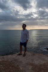 Young man in a white shirt in Calo d es Mort on the island of Formentera in Spain in the summer of 2021