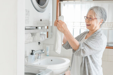 洗濯をする高齢者女性
