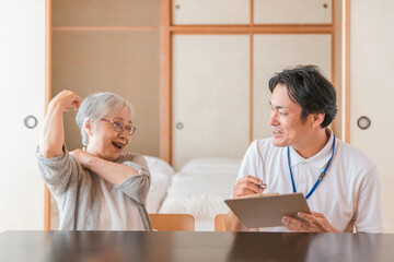 Obraz premium 元気な高齢者女性と男性スタッフ（笑顔） 