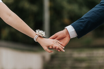 bride and groom holding hands close up