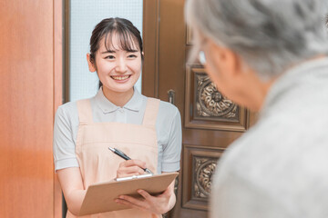 高齢者住宅に訪問する女性（書類）
