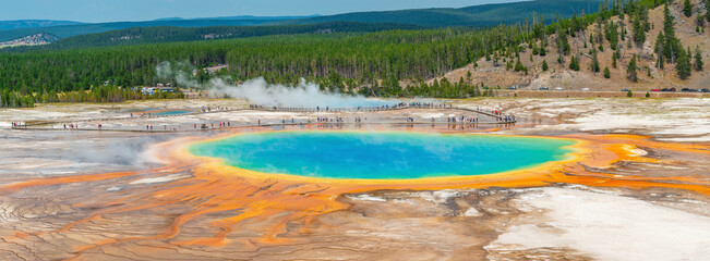 Grand Prismatic Spring panorama with people tourists walking on elevated walkway in summer, Yellowstone national park, Wyoming, USA.