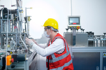 Quality control (QC) engineer monitoring and checking machine system in manufacturing factory