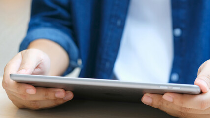 Close up of man hand using digital tablet for working at home, online study, telecommunication