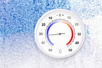 Celsius scale thermometer on a frozen window shows minus 32 degrees