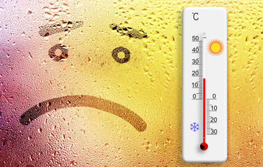Rainy day. The sadness  emoji and thermometer on the wet window. Ambient temperature plus 18 degrees