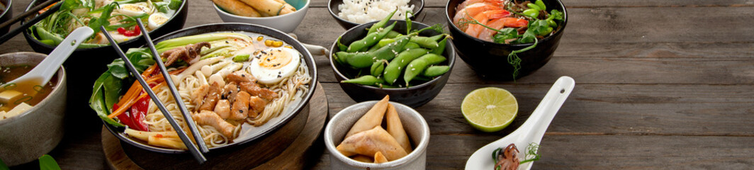 Asian dishes and snacks on wooden background.