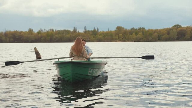 A couple in love a man and a young girl ride a rowboat on the lake on a summer day. Slow motion
