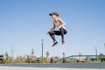 Sportive woman working out on the sports ground in sunny summer day