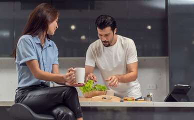 Handsome husband prepares a healthy breakfast salad for his wife and beautiful girlfriend to sit on the kitchen counter while having coffee in the kitchen at home. 