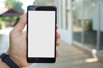 Adult hand holding a smartphone outside a store with blank copy space screen for text message or information content