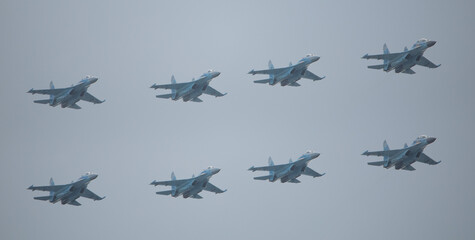 Three military fighter jets as part of a unit in the sky.