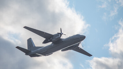 Naklejka na ściany i meble Military twin-engine transport aircraft on sky background.