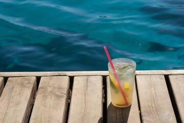 cold drink standing on wooden floor by the beach
