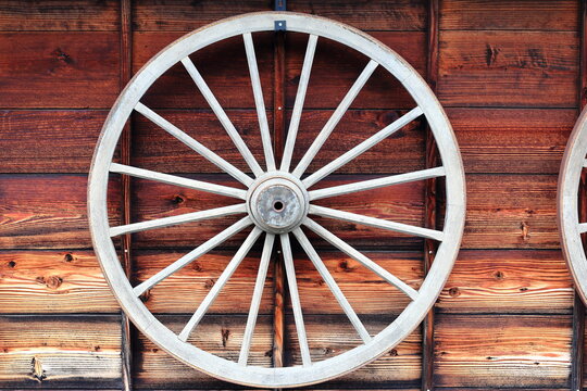 木の壁に掛けられた古い荷車の車輪