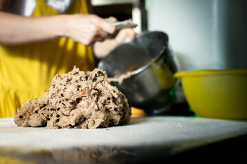 Rye dough with chocolate and hazelnuts woman baker lays out on the table