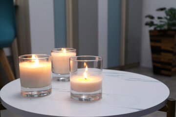 luxury aroma lighting aromatic scented candle glass displayed on white marble table to creat romantic and relax ambient on valentine day with background of modern living room at night