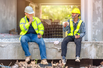 Construction worker, foreman sits and talks with the engineer who supervises the construction site....
