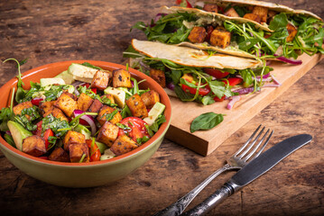 Vegan salad bowl with vegetables and fried tofu top view and tacos with vegetable salad - vegetarian cuisine.